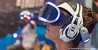 Person mit Virtual-Reality-Brille, die immersive VR-Technologie erlebt, wie sie auf Messen angeboten wird.